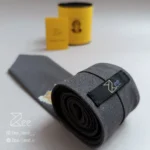 جزییات پشت کراوات لینن یونیسکس به رنگ طوسی با تگ برند زی
