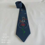 جزییات کراوات فانتزی لینن یونیسکس با رنگ سرمه‌ای و با طرح شازده کوچولو گلدوزی شده با دست