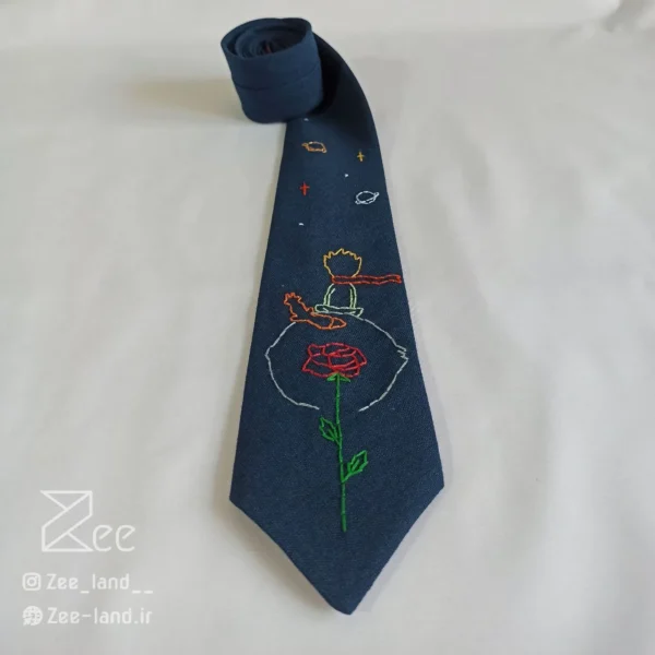 جزییات کراوات فانتزی لینن یونیسکس با رنگ سرمه‌ای و با طرح شازده کوچولو گلدوزی شده با دست