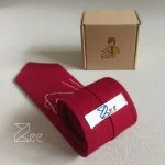 جزییات پشت کراوات لینن یونیسکس به رنگ زرشکی با تگ برند زی
