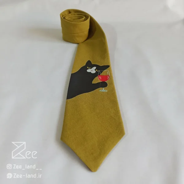 جزییات کراوات فانتزی چاپی لینن یونیسکس به رنگ زرد تیره و با طرح گربه ای که جام شراب در دست دارد، چاپ شده