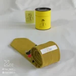 جزییات پشت کراوات لینن یونیسکس به رنگ زرد تیره با تگ برند زی