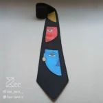 جزئیات کراوات خاص فانتزی لینن یونیسکس به رنگ مشکی و با طرح سه نیمرخ زرد، قرمز و آبی نقاشی و چاپ شده