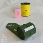 جزییات پشت کراوات لینن یونیسکس به رنگ سبز با تگ برند زی
