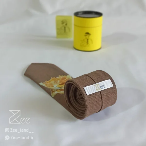 جزییات پشت کراوات لینن یونیسکس به رنگ قهوه‌ای روشن با تگ برند زی
