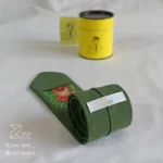 جزییات پشت کراوات لینن یونیسکس به رنگ سبز با تگ برند زی