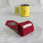 جزییات پشت کراوات لینن یونیسکس به رنگ زرشکی با تگ برند زی