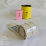 جزییات پشت کراوات لینن یونیسکس به رنگ کرمی با تگ برند زی