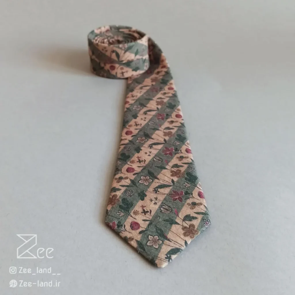 جزییات کراوات وینتیج از جنس کتان، کراوات کلاسیک با طرح گل‌های رنگارنگ روی پارچه راه راه دوخته شده با دست