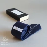 جزییات پشت کراوات ساتن رسمی به رنگ سرمه‌ای با تگ برند زی