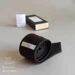 جزییات پشت کراوات ساتن رسمی به رنگ مشکی با تگ برند زی