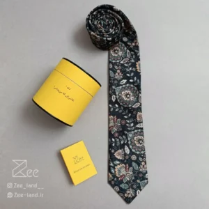 کراوات مخمل خیال با زمینه ی سبز تیره و طرح بوته های سنتی کرمی، کراوات مخمل دست‌دوز همراه با جعبه استوانه فلزی نگهدارنده کراوات و دفترچه راهنمای نگهداری