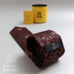 نمای پشت کراوات ایرانی رنج نقاش از جنس مخمل با طرح های اسلیمی ایرانی با تگ برند زی، همراه با جعبه استوانه فلزی نگهدارنده کراوات و دفترچه راهنمای نگهداری
