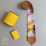 کراوات فانتزی غروب 1 از جنس لینن با طرح منظره غروب و جاده، چاپ باکیفیت، دوخت کاملاً دست‌دوز، به‌همراه جعبه فلزی اختصاصی و دفترچه راهنما.