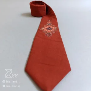 کراوات سنتی قالی ۱ از جنس لینن با طرح الهامگرفته از نقوش اصیل فرش ایرانی روی زمینه آجری، چاپ باکیفیت، دوخت کاملاً دستدوز از نمای نزدیک
